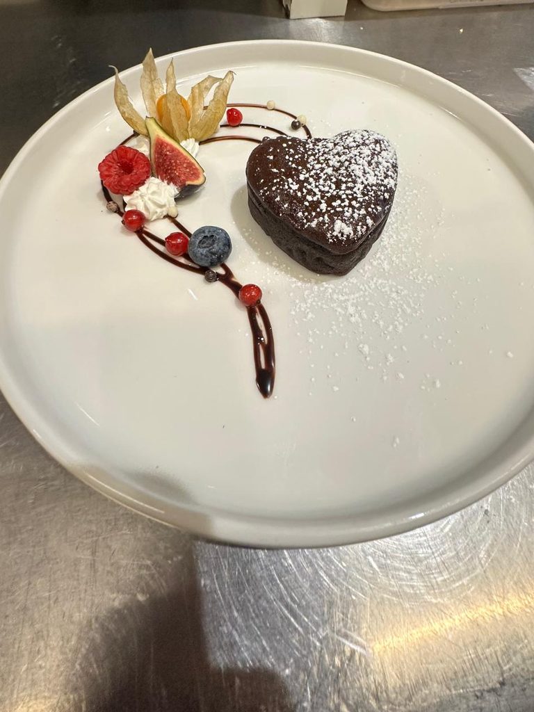 Tortino al cioccolato a forma di cuore con frutti di bosco