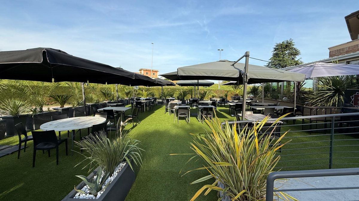 Il giardino sul prato con i tavoli sotto gli ombrelloni